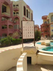 2 Bedroom Apartment with pool view في شرم الشيخ: علامة أمام مبنى به مسبح