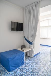 una camera con un letto e un computer portatile su un tavolo di La Casetta a Capri