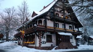 una casa grande con nieve en el techo en Kräuterhex' Reutin en Alpirsbach