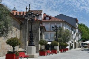 a street with red benches in front of a building at Guest House in Ponte de Lima