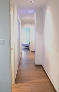 a long hallway with white walls and wooden floors at Apartamento PLAYA 5 minutos a pie MODERNO Y CONFORTABLE CABANYAL in Valencia