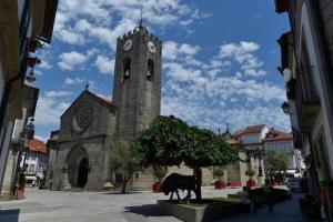 a church with a clock tower with a statue of a cow at Guest House in Ponte de Lima