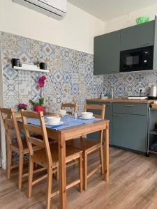 Holiday Studio in Centro Storico Intra في إنترا: مطبخ مع طاولة وكراسي خشبية في مطبخ