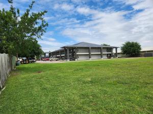 a large building with a grass field in front of it at Express Inn Hobby Airport in Houston