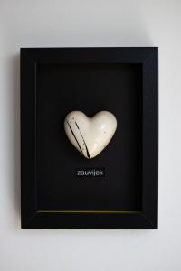 a white heart shaped vase in a black frame at Deluxe Apartments "Nona Fa" in Rijeka