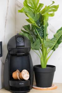 uma cafeteira sentada numa mesa ao lado de um vaso de plantas em Deluxe Apartment and Studio "Nona Fa" em Rijeka