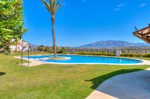 basen z palmą i góry w tle w obiekcie CALA BLUE VIEWS w mieście La Cala de Mijas