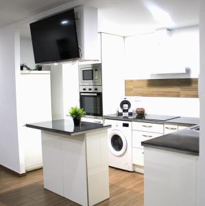 a white kitchen with a washer and dryer at Apartamento PLAYA 5 minutos a pie MODERNO Y CONFORTABLE CABANYAL in Valencia