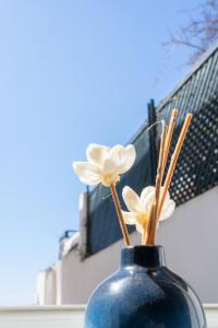 un vaso blu con fiori bianchi dentro di La Casetta a Capri Altre 15 foto