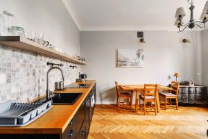 een keuken met een spoelbak en een tafel met stoelen bij Designer flat in the heart of Old Town in Warschau
