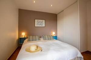 ein Schlafzimmer mit einem Bett mit Hut darauf in der Unterkunft Appartements MISTRETTA 33 Bouddha Zen 34 Arts Appart 44 NY City in Sainte-Maxime