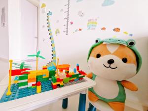 ein ausgestopfter Teddybär steht neben einem Spielzeugtisch in der Unterkunft Legoland - HappyWonder Suite for Family ,Cozy, Wifi with Nice Garden Pool View! in Nusajaya