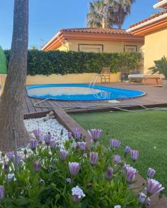 a backyard with a swimming pool and purple flowers at MANDARINA in Riumar
