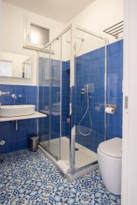 e bagno piastrellato blu con doccia e servizi igienici. di La Casetta a Capri