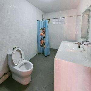 a bathroom with a white toilet and a sink at Marin House Pattaya in Pattaya North