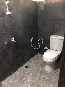 ein Bad mit einem WC in einer schwarzen Wand in der Unterkunft Myro Cottage in Weligama
