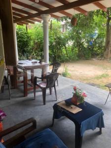 eine Terrasse mit Tisch und Stühlen auf einer Veranda in der Unterkunft Myro Cottage in Weligama