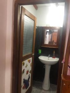 ein Badezimmer mit Waschbecken, Toilette und Spiegel in der Unterkunft Myro Cottage in Weligama