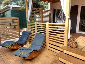 a porch with a chair and a table on a deck at PAMARA Mobile Home in Biograd na Moru