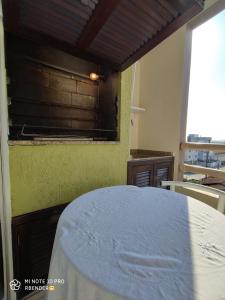a dining room with a table and a yellow wall at Apartamento completo em Joinville no Costa e Silva - Há 50 km das Praias SC in Joinville