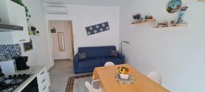 sala de estar con mesa y sofá azul en La Siciliana Trapani Apartment en Trapani