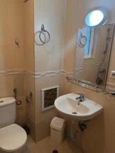 a bathroom with a sink and a toilet and a mirror at Sunny Beach Apartment - Kuban / Bravo 5 in Sunny Beach