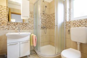 a bathroom with a shower and a sink and a toilet at Apartmani Justić in Njivice