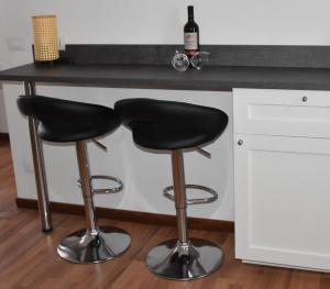 two black bar stools in front of a kitchen counter at R & A Minerva Suites in Pavia