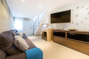 a living room with a couch and a flat screen tv at RNET - Port Estrella 31 - Roses Costa Brava in Roses