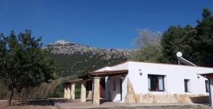 a white building with a mountain in the background at Casa Marcella in Dorgali