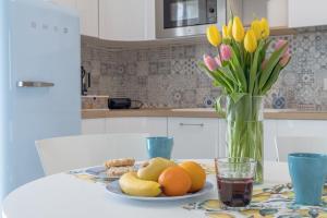 una mesa con un plato de fruta y flores en un jarrón en Casa Made' Luxury and Exclusive home in Polignano a Mare en Polignano a Mare