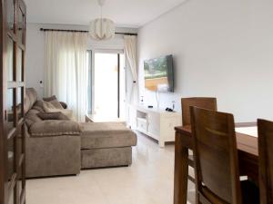 een woonkamer met een bank en een tafel bij Apartamento LUXURY en ROQUETAS DE MAR - PLAYA SERENA Urbanización VILLA ROMANA in Roquetas de Mar