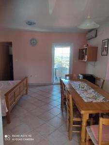 a dining room with a table and chairs and a clock on the wall at Apartments Nino in Štivan