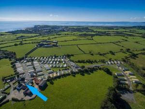 an aerial view of a village with a blue arrow at Family stay by the beach in Chwilog