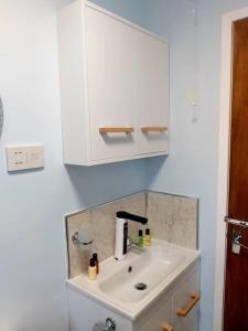 a bathroom with a sink and a white cabinet at Family stay by the beach in Chwilog