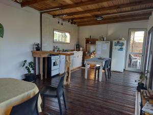 a kitchen with white appliances and a wooden floor at KIYA surf parador in Colonia Chapadmalal