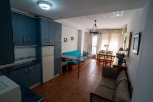 a kitchen and living room with blue cabinets and a couch at La Posada De Carmen in Níjar