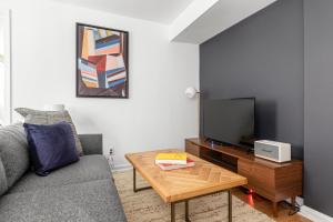 ワシントンにあるDupont Circle 1BR nr U St Metro Glens Mkt WDC-178のソファとテーブル、テレビのあるリビングルーム