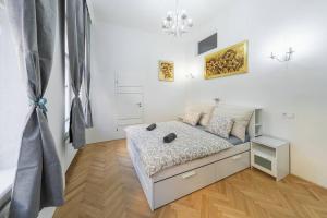 - une chambre blanche avec un lit dans l'établissement Opletal Apartment, à Prague