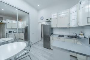 La cuisine est équipée de placards blancs et d'un réfrigérateur en acier inoxydable. dans l'établissement Opletal Apartment, à Prague