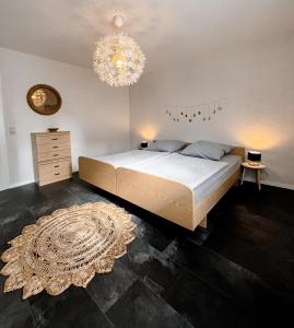 Un dormitorio con una cama grande y una lámpara de araña. en Gemütliche Ferienwohnung für 4 Personen en Baumholder