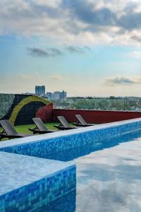 una fila di sedie seduta accanto alla piscina di Hotel Kavia Premium - Paseo Montejo a Mérida