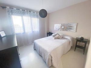 um quarto com uma cama branca e uma janela em El rinconcito de la Isla em San Fernando