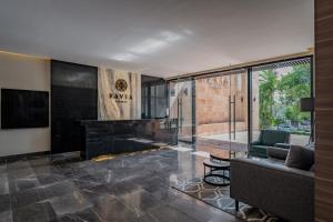 - un salon avec un canapé et un piano dans l'établissement Hotel Kavia Premium - Paseo Montejo, à Mérida