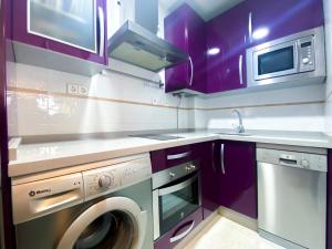 a kitchen with purple cabinets and a washing machine at El rinconcito de la Isla in San Fernando