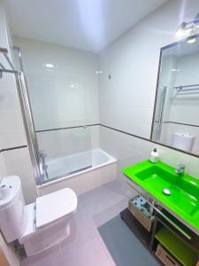 uma casa de banho com um WC e um lavatório verde em El rinconcito de la Isla em San Fernando