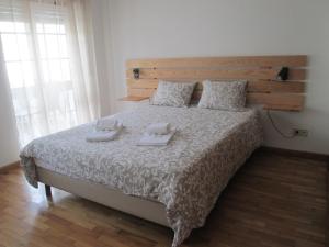 a bedroom with a bed with two towels on it at Baleal Holiday House in Baleal