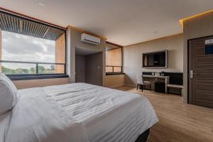 una camera d'albergo con un grande letto e una scrivania di Hotel Kavia Premium - Paseo Montejo a Mérida