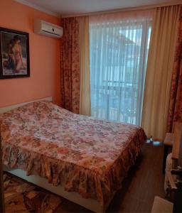 a bedroom with a bed and a large window at Вилла Астория 3 in Elenite