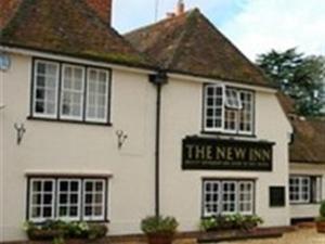 a white building with a sign for the new inn at The New Inn in Reading